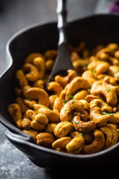 a skillet filled with fried cashews on top of a table