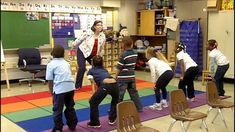 a group of children standing around each other in a classroom