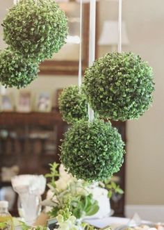 the table is set with flowers and greenery hanging from it's centerpieces