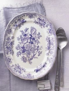 a purple and white plate sitting on top of a table next to a silver fork