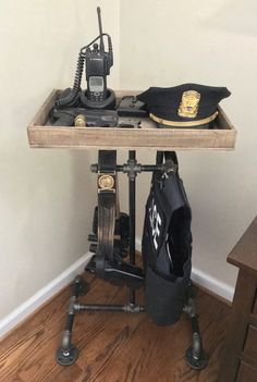 an old fashioned radio sitting on top of a wooden table next to a pair of police hats