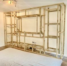 an unfinished bed frame in a room with white walls and wood flooring on the wall