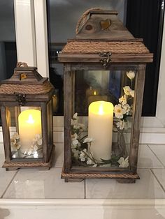 two lit candles sitting on top of a counter