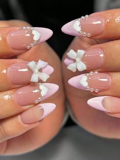 a woman's hands with pink and white nail designs on their fingertipss,