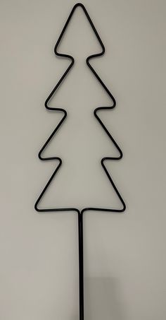 a black metal christmas tree on a white wall