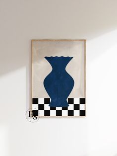 a blue vase hangs on the wall above a black and white checkered tablecloth