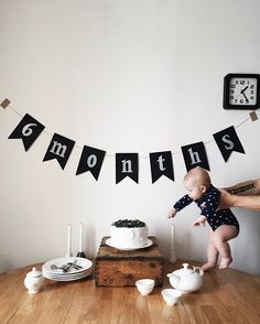 a baby standing on its hind legs in front of a cake