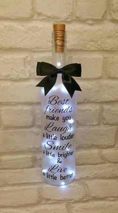 a lighted bottle with a black bow on it that says, be true and make you laugh