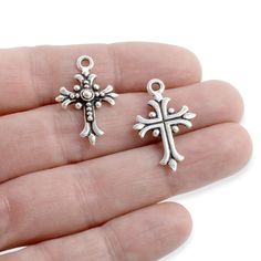 Material: Pewter, Plated with .999 Fine Silver and antique finish Amount: 2 pendants Size: 17mm x 26mm; 2mm stringing hole Shape: Fleur Cross Color: Antique silver with a raised design on the front and a flat back This large and regal fleur-de-lis cross is a beautiful way to make a statement. The three petals of the flower are said to represent faith, wisdom, and chivalry. Use this cross to add class and elegance to your jewelry projects or wedding invitations! These TierraCast® pendants are mad Pewter Pendant, Cross Design, Cross Jewelry, Cross Designs, Cross Charms, Antique Finish, Jewelry Projects, Fine Silver, Cross Pendant