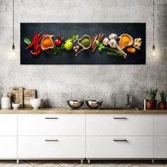 a kitchen with white cabinets and an art work on the wall