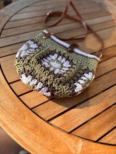 a crocheted purse sitting on top of a wooden table