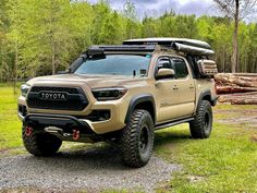 a tan toyota pickup truck parked in the woods