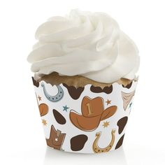 a cupcake with white frosting and cowboy themed decorations on it's wrapper