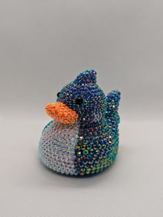 a small blue duck with multicolored beads on it's body