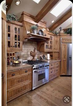 a kitchen with wooden cabinets and stainless steel stove top oven in the middle of it