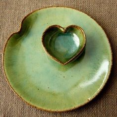 a green heart shaped dish on top of a table