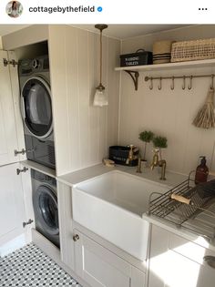 a washer and dryer in a white kitchen with black and white floor tiles