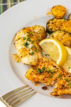 a white plate topped with chicken and lemon slices