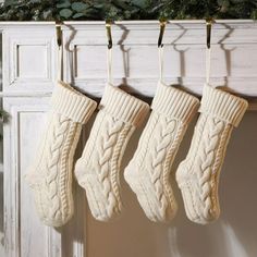 three white socks hanging from a mantle