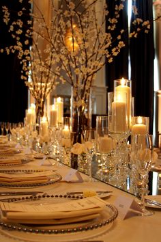 a long table is set with candles and place settings