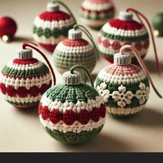 crocheted christmas ornaments are arranged in rows on a table with red, white and green balls