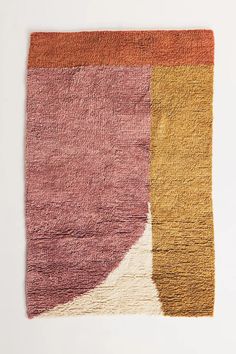 an area rug with different colors and shapes on the floor, including pink, orange, yellow, and white