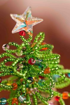 a green christmas tree decorated with beads and a star ornament on it's top