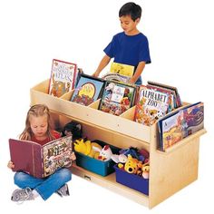 two children are sitting on the floor reading books