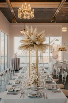 an elegant table setting with tall centerpieces and flowers