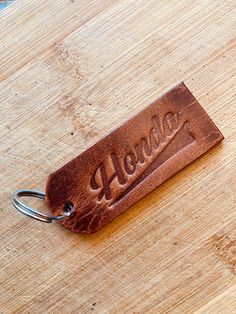 a leather keychain with the word hello written on it