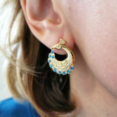 Opulent and beautiful peacock earrings handmade in our Worthing studio. The crowning glory of our Passage to India collection, these peacock ear studs feature a pair of highly detailed birds, complete with extravagant 'eye spotted' tail feather plumes and teeny tiny fan-shaped corona crests on their heads. Available with, or without, iridescent blue opals. These statement peacock stud earrings measure 20mm in diameter. They come with a secure stud fastening, which ensures you'll never lose them, Elegant Earrings With Peacock Design For Gift, Elegant Peacock Design Earrings As Gift, Elegant Sterling Silver Earrings With Peacock Design, Elegant Peacock Colored Earrings For Gift, Elegant Peacock-colored Earrings For Gift, Elegant Peacock-colored Earrings As A Gift, Handmade Elegant Peacock Jewelry, Elegant Handmade Peacock-colored Jewelry, Sterling Silver Peacock Design Jewelry