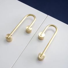 two gold handles on a white surface