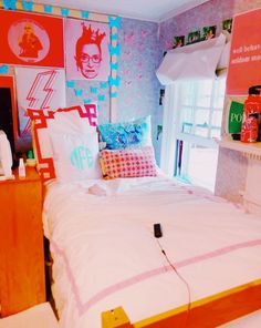 a bed room with a neatly made bed and posters on the wall