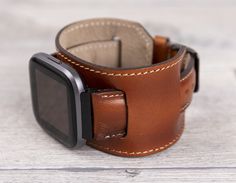 "Full Grain leather burnished tan cuff band for Fitbit Versa 1-2-3-Lite-Sense This watch strap is medium size and fits 6\"-7.6\" (150-190mm) wrists. Four different color options for adapters (Silver, Black, Rose Gold, Gold). Adapter color and buckle color will be same. Shipping takes usually 3-4 business days (via USPS First Class-Free), 2 business days (via FedEx 2Day) and 1 business day (via FedEx Overnight). To Europe: 1-2 business days via TNT Express. Customization: We can write messages, n Brown Cuff Watch With Leather Strap, Brown Cuff Leather Strap For Watch, Brown Leather Strap Cuff Watch, Brown Leather Bracelet With Wrist Strap, Brown Leather Cuff Watch Band, Brown Leather Cuff Watch Accessories, Rugged Brown Leather Watches, Adjustable Leather Watch Bands With Wrist Strap, Brown Cuff Watch With Bracelet Strap