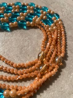 Double Strand Waist Bead – a radiant creation meticulously crafted with warm tan glass crystal seed beads, complemented by larger, vibrant blue glass seed bead accents. This double-strand waist bead not only embodies the warmth of a sunlit horizon but also radiates a harmonious charm, offering a captivating and adjustable fit that transcends beauty and symbolism. 🌅 Tan Glass Crystal Seed Beads - Radiant Warmth: Toulepleu is adorned with a radiant array of tan glass crystal seed beads, capturing Orange Multi-strand Beaded Necklaces For Beach, Orange Multi-strand Polished Beaded Necklaces, Orange Multi-strand Beaded Necklace With Polished Beads, Orange Multi-strand Polished Beaded Necklace, Bohemian Multi-strand Waist Beads With Spacer Beads, Bohemian Multi-strand Beaded Waist Beads, Bohemian Multi-strand Waist Beads, Bohemian Style Multi-strand Beaded Waist Beads, Multi-strand Czech Glass Beaded Necklace