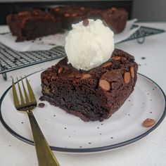 a piece of chocolate cake with ice cream on top and a fork next to it