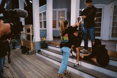 a group of people standing on top of a wooden floor next to stairs with cameras around them