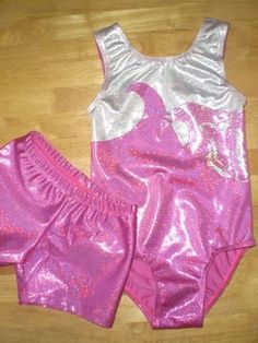 two pieces of pink and silver clothing sitting on top of a wooden floor next to each other