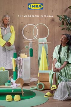 two women are sitting on the floor in front of some colorful objects and one is holding a heart