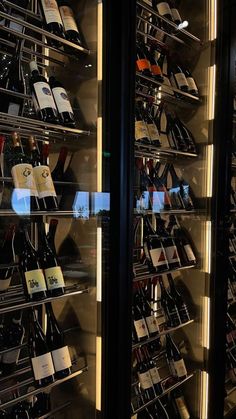 there are many wine bottles in the glass case