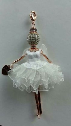 a ballerina keychain with a white tutu skirt and beaded ballet shoes