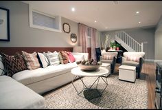 a living room filled with white furniture and lots of pillows