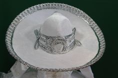 Authentic Mexican Charro Mariachi Sombrero -Handcrafted in Mexico by experienced Hands -Made from Ivory/ White/ Black Suede -Gold/Silver Metallic Embroidery along sides and top of Sombrero -Adjustable Gold/Silver Metallic Sombrero Tie -Perfect for both Boys and Girls, Adult sizes available Mariachi Hat, Mexican Sombrero, Metallic Embroidery, Authentic Mexican, Ivory White, Quince, Black Suede, Metallic Silver, Silver Gold