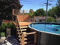 an above ground swimming pool with steps leading up to the deck and hot tub in backyard