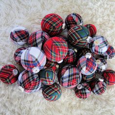 a pile of red, black and white plaid fabric christmas ornaments on a furry surface