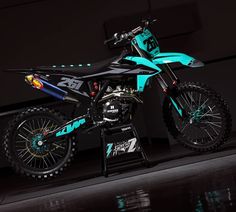 a blue and black dirt bike sitting on top of a stand