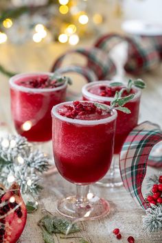 two glasses filled with cranberry and pomegranate drink on top of a table