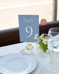 a table set with place cards and wine glasses