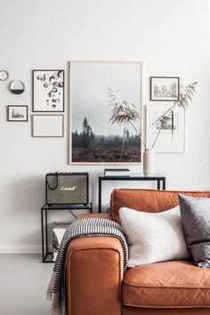 a living room filled with furniture and pictures on the wall