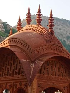 an intricately designed building with mountains in the background